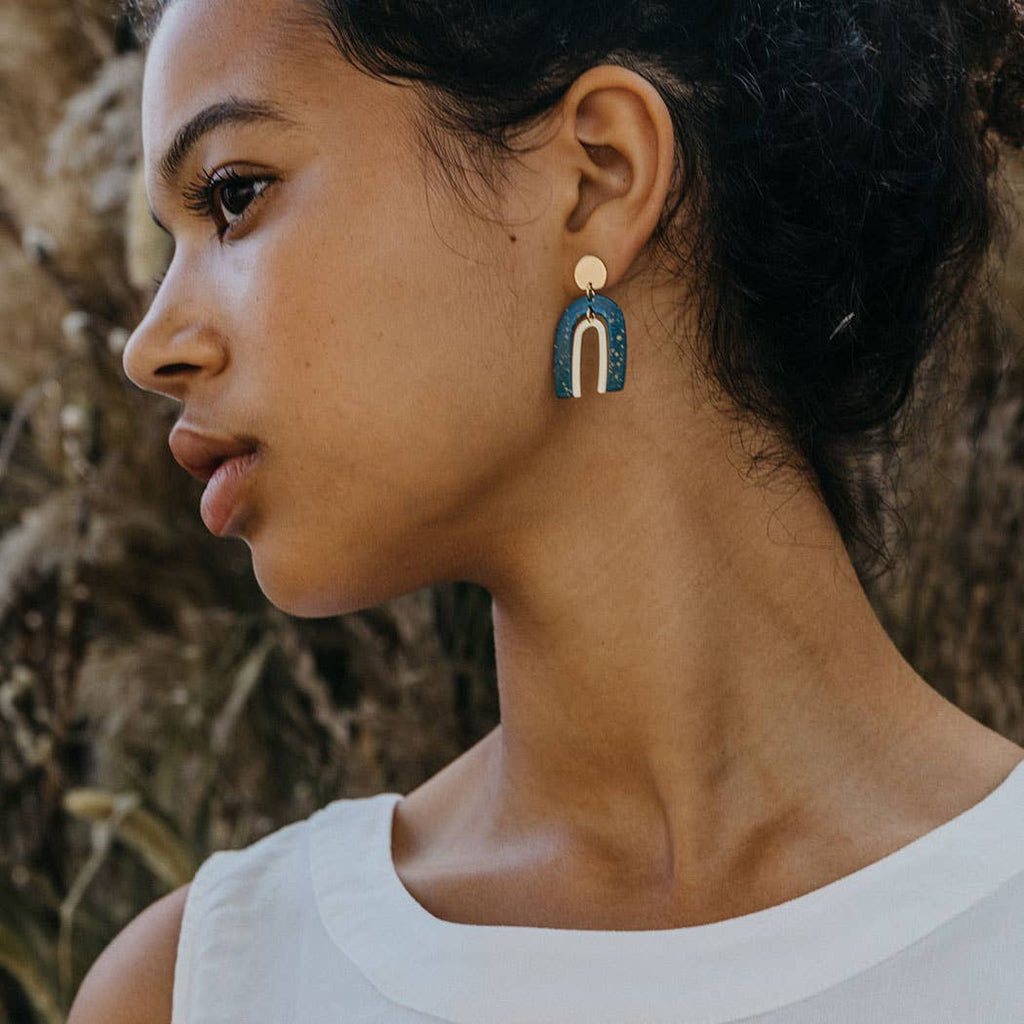 Drop earrings inspired by the Arches and starry sky of Moab, Utah. Surgical steel ear wires in blue and gold. Made by Amano Studio.