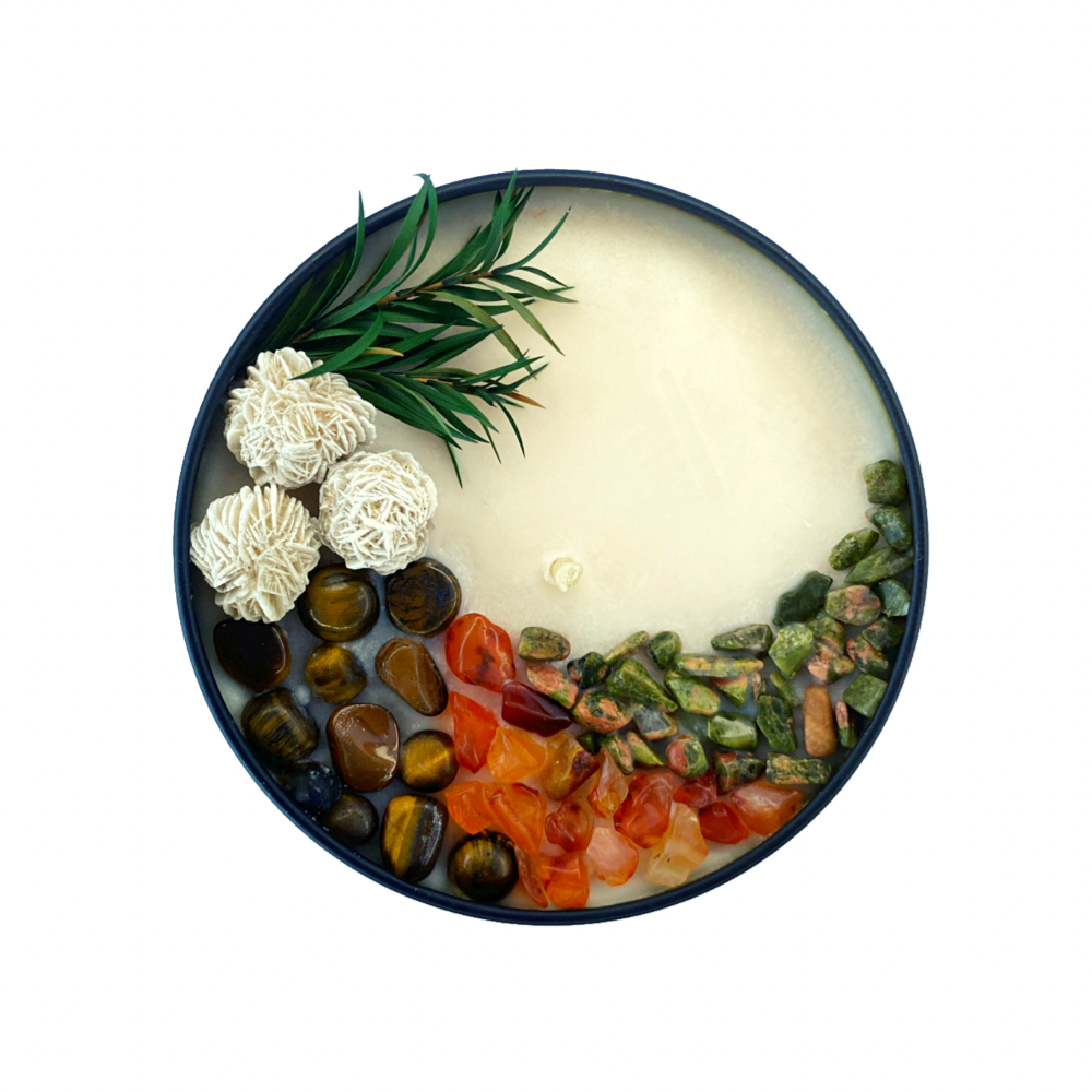 The 8oz Soy Crystal Intention Candle features desert rose, tiger's eye, carnelian, unakite, and jasper with lemongrass and ginger essential oils; it's hand-poured with soy wax and comes with a mini selenite wand to keep all stones within cleansed and charged