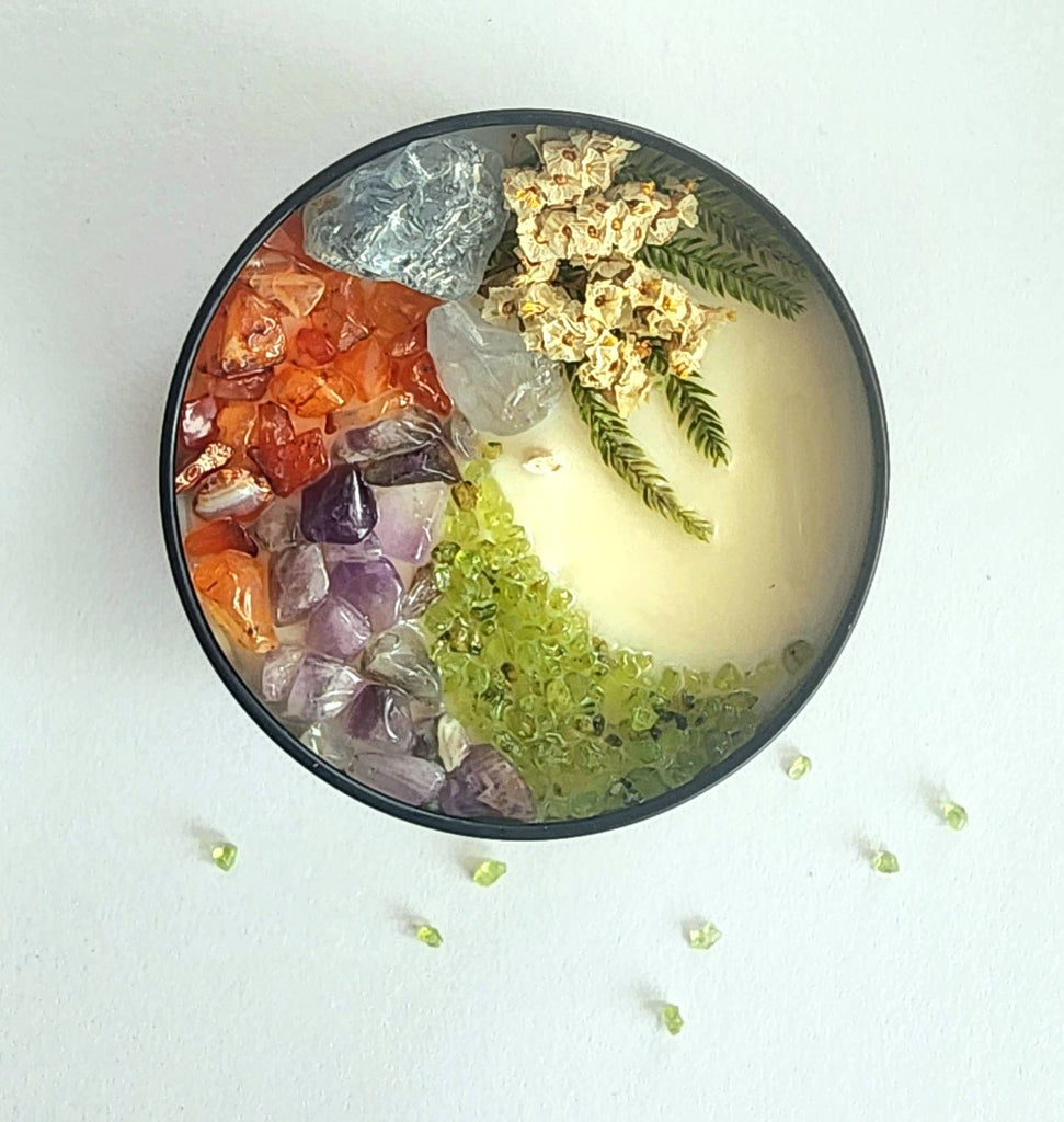 The 8oz Soy Crystal Intention Candle features celestite, carnelian, amethyst, and peridot crystals with a sweet orange + vanilla scent; it's hand-poured with 100% American soy wax, essential oils, and phthlate-free fragrance; all candles come with a mini selenite wand to keep all stones within cleansed and charged